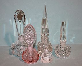 Five Glass Perfume Bottles Description: Five Glass Perfume Bottles; four clear glass and one peach color glass. One clear glass bottle has an edge with an image of the Eiffel Tower. 4 1/2