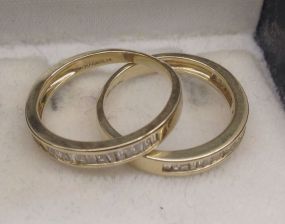 Two 14KT yellow lady's cast diamond anniversary bands Two 14KT yellow lady's cast diamond anniversary bands with a tapered shanks with a bright polish finish. Trademark is Magnolia. Containing: Forty-five channel set baguette cut (tapered) diamo