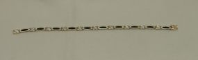 One stamped 10KT yellow gold lady's cast synthetic sapphire and diamond bracelet One stamped 10KT yellow gold lady's cast synthetic sapphire and diamond bracelet with a 14k hidden clasp with a bright polish finish. Containing: Five channel set b