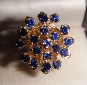One stamped 14KT yellow gold lady's cast sapphire cluster ring One stamped 14KT yellow gold lady's cast sapphire cluster ring with a split shank with a bright polish finish. Containing: Nineteen prong set round standard brilliant cut synthetic b