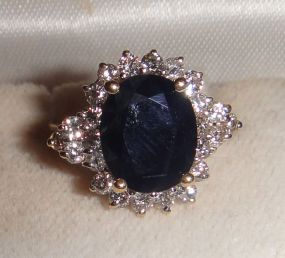 One stamped 14KT yellow gold lady's cast sapphire and diamond cluster ring One stamped 14KT yellow gold lady's cast sapphire and diamond cluster ring with a split shank with a bright polish finish. Containing: One prong set oval standard brillia