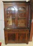  Empire Bookcase/Secretary Circa 1840 mahogany bookcase fold over secretary, two glass doors with interior shelves over two drawer, two door base supported by bun feet. (slight damage to veneer) 45