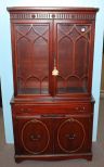 Mid twentieth century mahogany China cabinet. Small cabinet with two glass doors having simple gothic, arch design on doors, drawer over two oval panel doors; 35 1/2