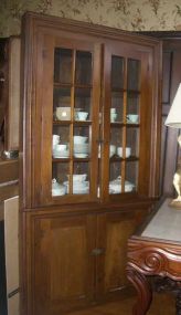 Walnut Corner Cabinet with 2 upper 8 Pane Glass Doors & 2 Raised Panel Doors in the Base