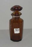 Tall amber perfume bottle with white flowers