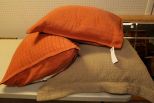 Two Orange Pillows & One Large Brown One