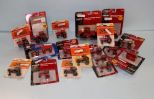 Sixteen small die cast tractors