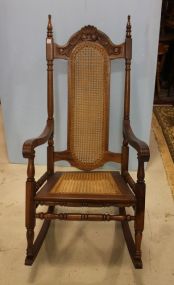 Highback Carved Arm Rocker Has cane seat and back; 48 1/2