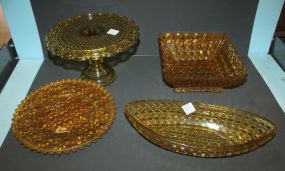 Group of Amber Depression Glass Pieces including Cake Stand, Round Tray, Boat, Square Bowl