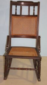 Walnut East Lake Sewing Rocker has cane seat and back; seat has a hole in the cane; 34