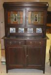 Oak Two Piece Kitchen Cabinet with Blue and White Tiles in Backsplash, Mirrored and Stained Glass Doors on Top