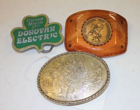 Gold Belt Buckle, 1984 World's Fair Medallion Buckle, and a Clover Shaped Donovan Electric Buckle