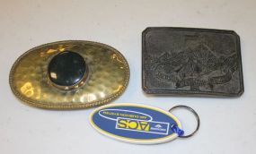 Gold Belt Buckle with Black Center Stone and a Teton Jackson Hole Wyoming 1829 Brass Buckle
