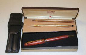 Set of Grey Buxton Pens in Leather Case, a Brown Pen with a Golf Club, and a Set of Gold Cross Pens in a Brown Case