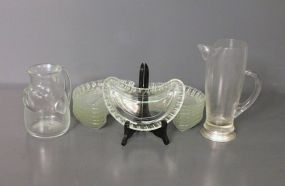 Two Glass Pitchers and Thirteen Clear Glass Bone Dishes Description