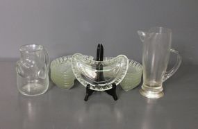 Two Glass Pitchers and Thirteen Clear Glass Bone Dishes Description