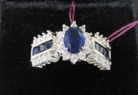 Oval Blue Colored Center Stone Surrounded by Clear Stones