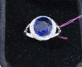 Round Blue Stone Ring with a Halo of Clear Stones in a Silvertone Mount