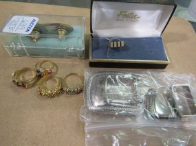 Four Costume Jewelry Rings, A Bullet Shaped Pin, a Tie Tack, and a Belt Buckle