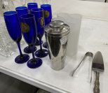Grouping of Champagne, Flower Bud Vases, Drink Shaker, and Sterling Handled Cake Knife and Metal Tongs