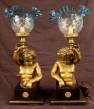 Pair of bronze cupid lamps with blue cut shades